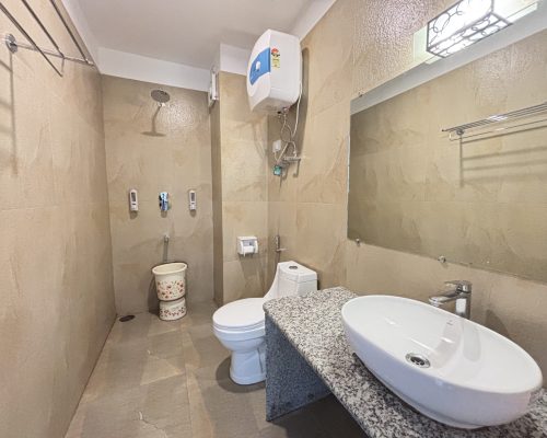 Spacious attached bathroom with modern amenities at Kunden Fortune Resort